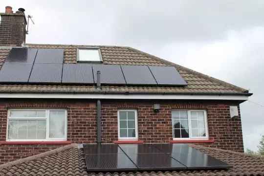 Solar panels on a house roof on an overcast day.