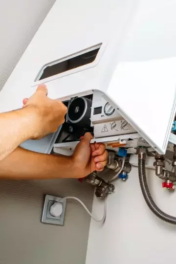 Hands closing the front panel of a boiler.