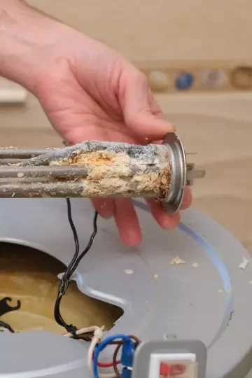 A burnt-out boiler heating element covered with lime coating.